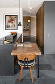 Open kitchen, small, folding dining table at the counter, hallway, and cloakroom in the background