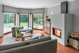 Living room with fireplace, upholstered sofa and coffee table, view of garden