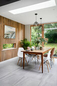 Bright dining area with skylight in front of oak plank wall paneling