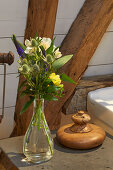 Bouquet of flowers on shelf in front of wooden beams