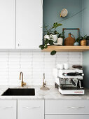 Helle Küchenzeile mit Marmorarbeitsplatte und Espressomaschine