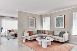 Modernes Wohnzimmer im Scandi-Stil mit Säulen-Couchtisch, cremefarbenem Leinensofa und Terrakotta-Teppich