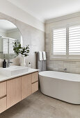 Modern Scandi-style bathroom in neutral tones with freestanding bathtub