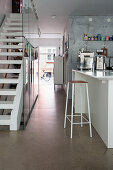 Open-plan kitchen with staircase and industrial-style concrete floor