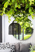 Terrassenecke mit Hängeleuchte, grünen Blättern und Spiegel