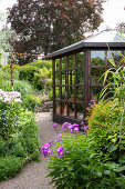 Glass house surrounded by flowering garden in summer
