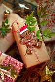Weihnachtlich verpacktes Geschenk mit Lebkuchenmann und rot-weißer Schnur