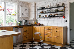 Scandinavian kitchen design with wooden cabinets and black and white checkered floor