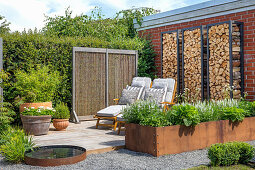 Idyllic garden with corten steel raised bed and deckchairs