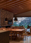 Dining area with pendant lights in an open living room at dusk