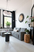 Grey upholstered sofa in bright living room with black accents