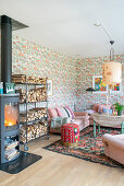 Wood-burning stove and firewood shelf in the living room with pink upholstered furniture and vintage wallpaper