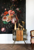 Vintage cupboard with decorative objects in front of floral tapestry