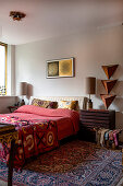 Double bed with colorful textiles and wooden decorations in the bedroom