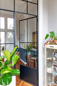 Stylish interior in old building with glass door and houseplants