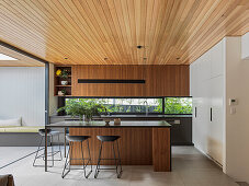Open kitchen with kitchen island, built-in cupboards and opening to the terrace
