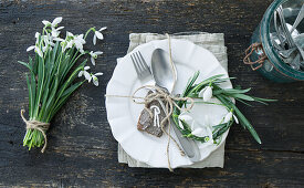 Place setting with bark place card, wreath of snowdrops and a bouquet next to it