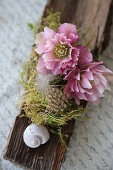 Decorated with bark, moss, feathers and Christmas rose blossoms (Helleborus niger)