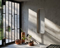 Sunlit room with concrete wall and window with metal detail