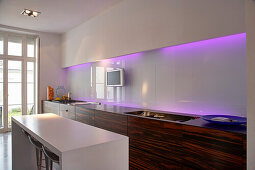 White galley kitchen with purple lighting and kitchen island