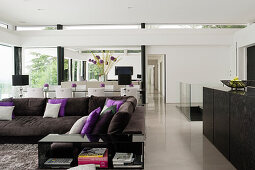 Modern living room with brown corner sofa and purple accents