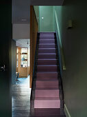 Modern staircase design with purple stair runner and dark colours