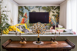 Farbenfrohes Wohnzimmer mit handgemalter Wandtapete und 1930er Pfauenlampe