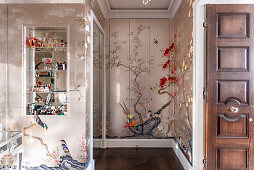 Floral wallpaper design in the dressing room with mirrored shelving and oak floorboards