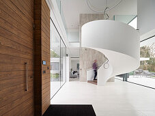 Großzügig gestalteter Eingangsbereich mit Wendeltreppe in Schneckenform und Holz-Elementen