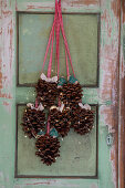 Door decoration made from pine cones with fairy lights