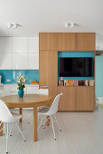 Dining area in wood, turquoise and white in a small flat