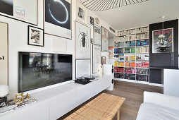 Modern eingerichtetes Wohnzimmer mit Bücherregal und Bildern