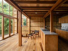 Wohnraum mit Holzbalken, Bambus und Küche in einem Haus in Ecuador