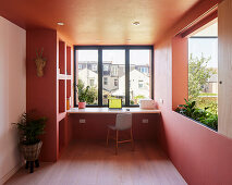Modern study with large window and coral red walls