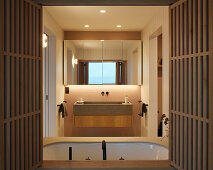 Badezimmer mit Holzlamellen, Waschbecken und Spiegel