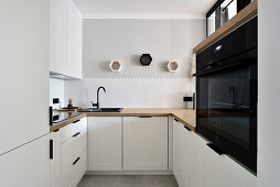 Moderne Küche mit weißer Einrichtung und Holzarbeitsplatte