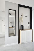 Hallway with mirror, white sideboard and minimalist decorations