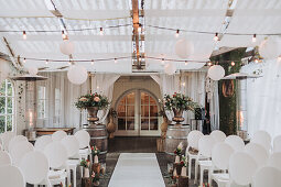 Dekorierte Zeremoniehalle mit Lampions und Blumenschmuck für eine Hochzeit