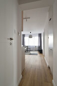 Hell und minimalistisch gestaltete Wohnung mit Holzboden und grauen Vorhängen