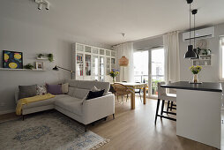 Bright living room with corner sofa, open-plan kitchen and dining area