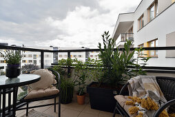 Gemütlicher Balkon mit Pflanzen und Sitzgelegenheiten in einem modernen Wohnkomplex