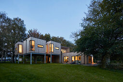 Modernes Holzhaus auf Stelzen bei Dämmerung, Scawby Brook, UK