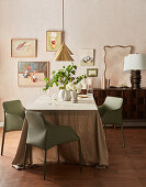 Dining room with linen tablecloth, modern chairs and wall artwork