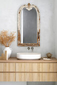 Bathroom with wooden washbasin and vintage mirror