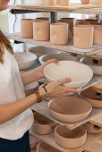 Pottery workshop with unglazed ceramic pots on shelves