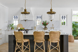 Open-plan kitchen with marble worktop and rattan bar stools