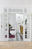 White-painted double doors with a view of the hallway and staircase