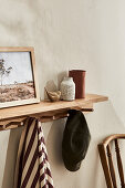 Wooden shelf with decoration and items of clothing in the entrance area