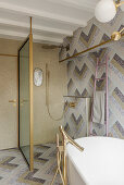 Bathroom with mosaic tiles and golden fittings