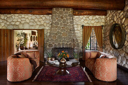 Rustic living room with stone walls, fireplace and upholstered sofas